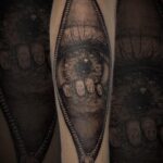 eye climbing out of zipper surrealism tattoo by vaeda russet