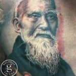 A black and grey realism portrait tattoo of Morihei Ueshiba by Donavan Moore.