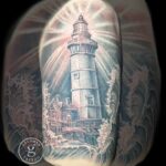 A black and grey realism tattoo of a lighthouse by Donavan Moore in Kelowna, BC.