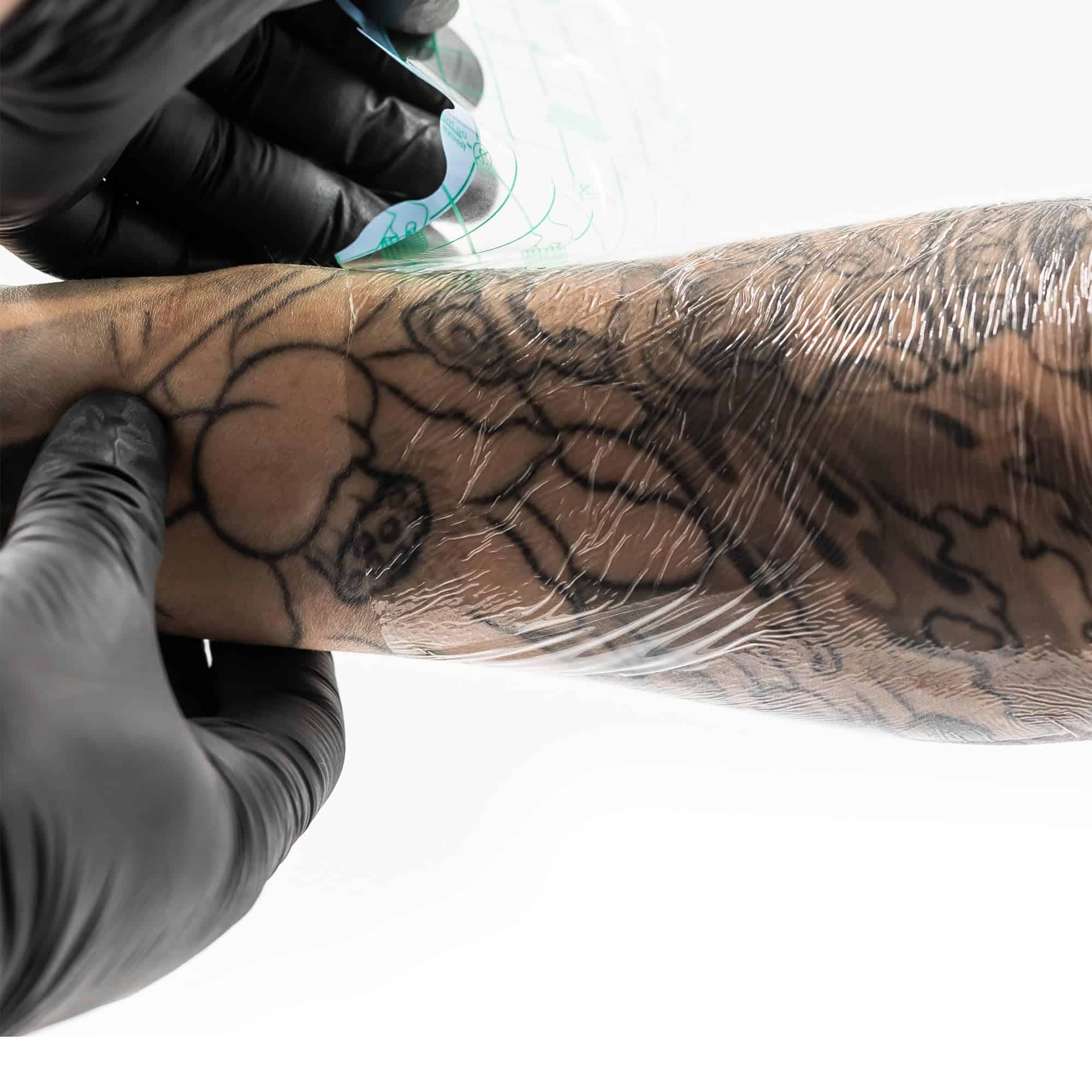 A second skin being wrapped over a tattoo at Evil Genius.